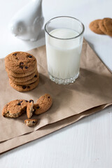 Tasty cookies and glass of milk on rustic wooden background