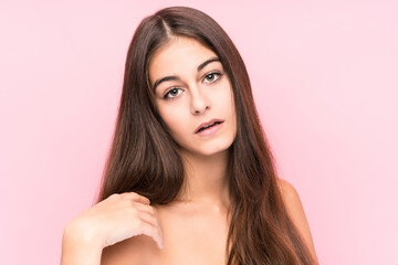 Young beauty caucasian woman against a pink background