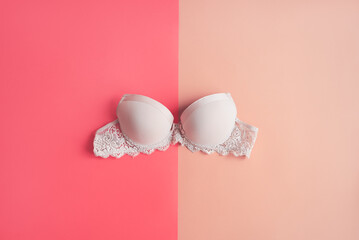 Classic bra of beige color on pink background. Women's lingerie. Women's health and Breast cancer awareness concept
