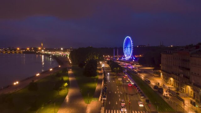Night Hyperlapse of Bordeaux, France Riverside with Ferris Wheel, Aerial forward