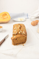 Fresh homemade pumpkin bread with pumpkin puree, cinnamon, nutmeg and seeds, placed on white background.