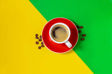 Cup of coffee on yellow and green background