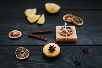 Natural handmade soap with dried slices of oranges and cinnamon on a dark background. Concept of Spa, body and skin care.  