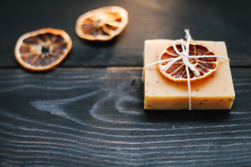 Natural handmade soap with dried slices of oranges on a dark background. Concept of Spa, body and skin care.  