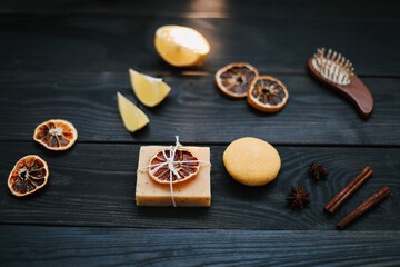 Natural handmade soap with dried slices of oranges and cinnamon on a dark background. Concept of Spa, body and skin care.  