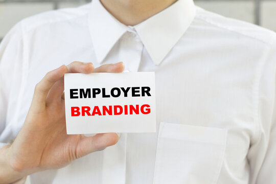 Businessman putting a card with text EMPLOYER BRANDING n the pocket