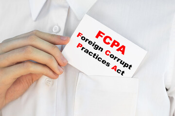Businessman putting a card with text FCPA Foreign Corrupt Practices Act on the pocket
