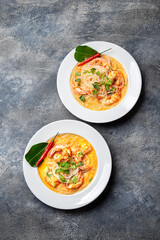 Asian Shrimp Tom Yam with funchosa on white plates. Top view, copy space