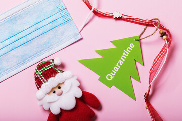Medical mask and Christmas accessories on a pink background. Quarantine concept