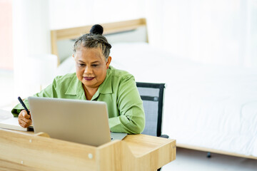 senior retirement Asian woman work from home with laptop computer in living room
