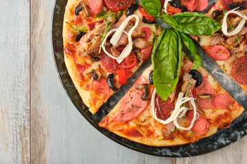 Supreme mixed pizza from top view on wooden background.