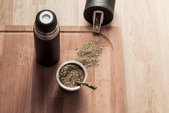 Juego de mate, mate, termo, yerbera sobre fondo color madera.
