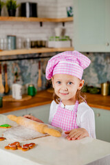 Girl in the kitchen kneads dough for glazed gingerbread