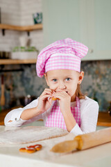 Girl in the kitchen kneads dough for glazed gingerbread