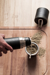 Mano de hombre cebando un Mate, fondo con los elementos del juego matero  © VP Varela Pamela