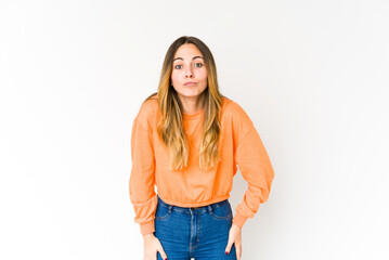 Obraz premium Young caucasian woman isolated on white background shrugs shoulders and open eyes confused.