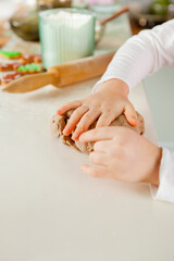child's fingers knead the dough for gingerbread