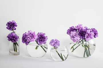 Bridal bouquet of lilac carnations in a round glass vase
