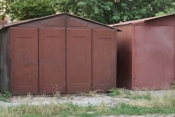 one red  iron garage with closed gates on the street