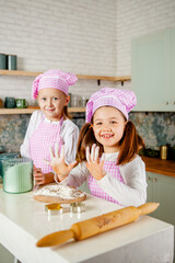 girls in the kitchen knead gingerbread dough.