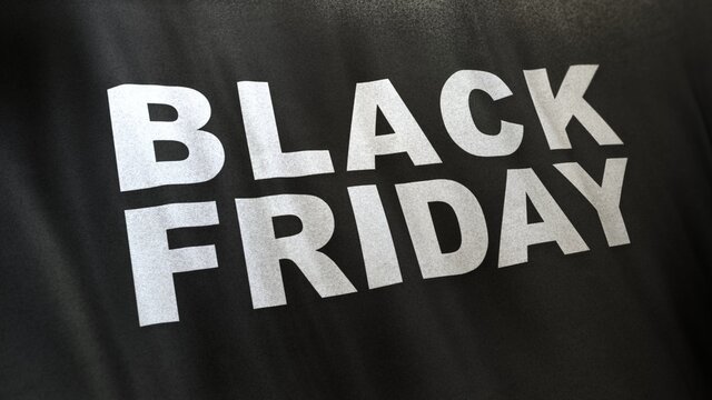 3D Illustration of Black Friday slogan in white letters on full frame black satin textured flag with selective focus