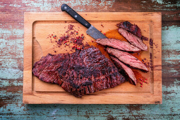 Barbecue wagyu bavette beef steak with red wine salt offered as top view on a rustic wooden board