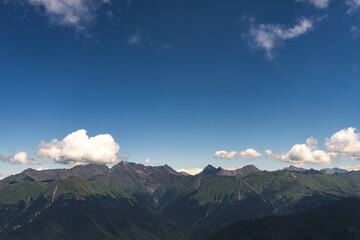 Magnificent panoramic view the coniferous forest on the mighty Mountains and beautiful blue sky background. Beauty of wild virgin Russian nature. Peacefulness.