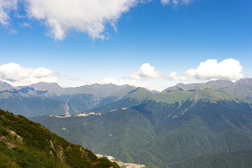 Naklejka premium Magnificent panoramic view the coniferous forest on the mighty Mountains and beautiful blue sky background. Beauty of wild virgin Russian nature. Peacefulness.
