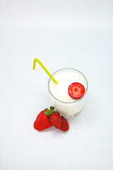glass of milk with strawberries top view