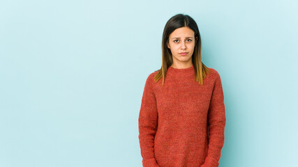Young woman isolated on blue background sad, serious face, feeling miserable and displeased.