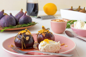 Caramelised figs with balsamic vinegar, rosemary, almonds and cottage cheese. Slow roasted homemade fruit dessert. White wooden table background. No people. Gordon Ramsey recipe.