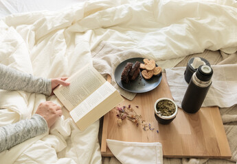 Desayuno argentino con mate y leyendo un libro en la cama, habitación luminosa y clara