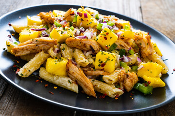 Chicken ragout with penne on wooden table