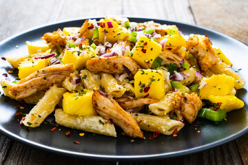 Chicken ragout with penne on wooden table