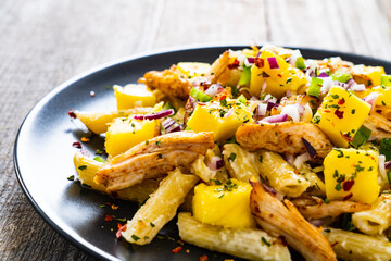 Chicken ragout with penne on wooden table