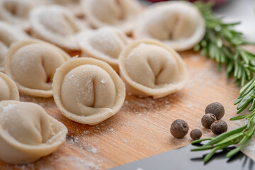 Raw raw homemade dumplings with seasonings on the kitchen table. Recipe for Russian dishes