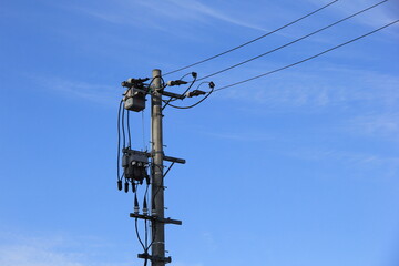 一方向にしか電線が延びていない電柱と青空