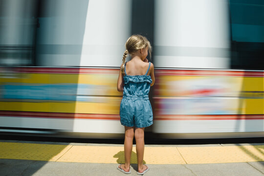 Rear view of girl waiting for train on platform