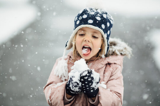 Little girl eating snow