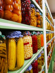Fresh organic healthy colourful pickle jars lined up on a shelf at supermarket