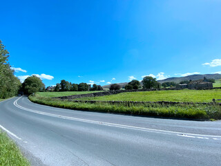 The B6265 road from Hetton village, to Cracoe, on a bright sunny day, with fields trees, and a vivid blue sky in, Skipton, UK