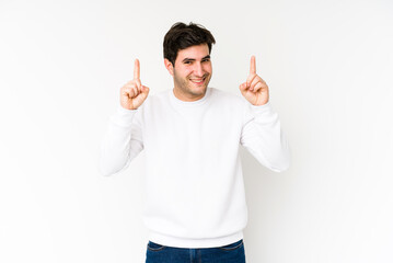Young man isolated on white background indicates with both fore fingers up showing a blank space.