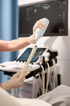 Gynecologist applies gel to a transvaginal ultrasound scanner for a female vaginal examination using an ultrasound machine. Ultrasound of the pelvic organs. Close-up shot. Selective focus.