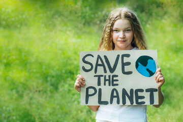 happy smiling child looking to camera holding a colorful save planet ecology poster. a school girl kid voted for forest protection from trash pollution. educational project for nature protection.