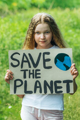 Fototapeta na wymiar child girl activist with save the planet poster in forest park. preteen kid volunteer fight against pollution, Global Warming, recycle garbage. Ecology environmental problem