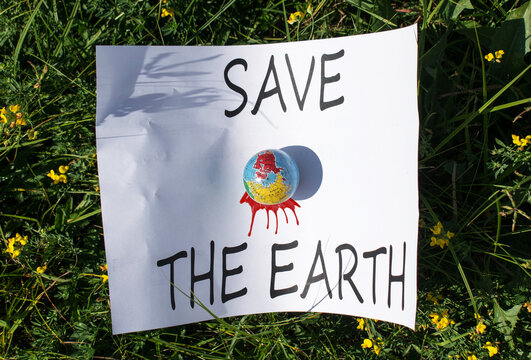 Banner with the message "Save the Earth." Protests for global warming awareness. The earth is bleeding