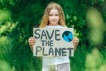 child girl activist with save the planet poster in forest park. preteen kid volunteer fight against...