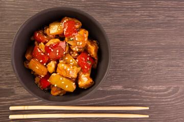 chess chicken in black bowl on wooden background - chinese food