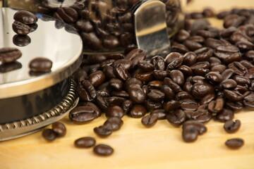Close up of coffee beans and a french press.