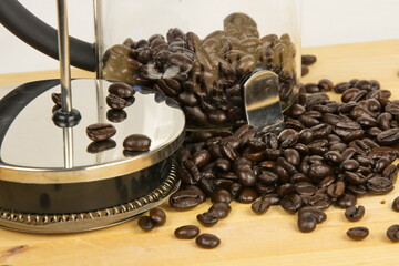 Close up of coffee beans and a french press.